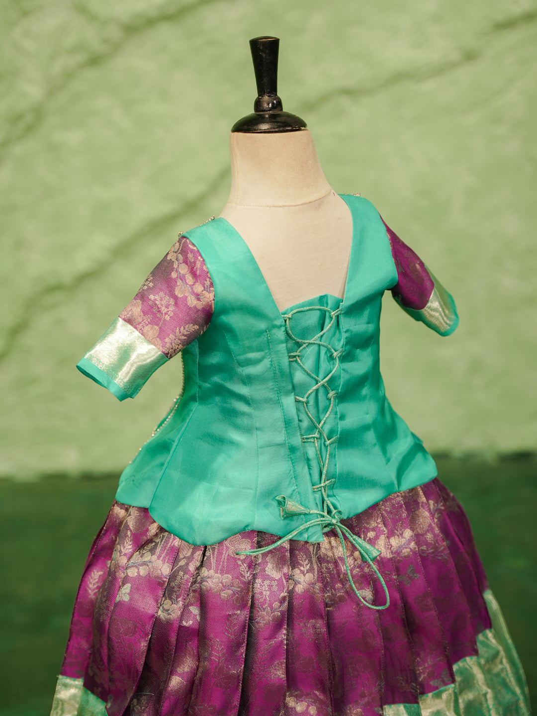 Mint and purple pattu pavadai in pure Kanchipuram silk with embellished blouse and zari skirt — back view