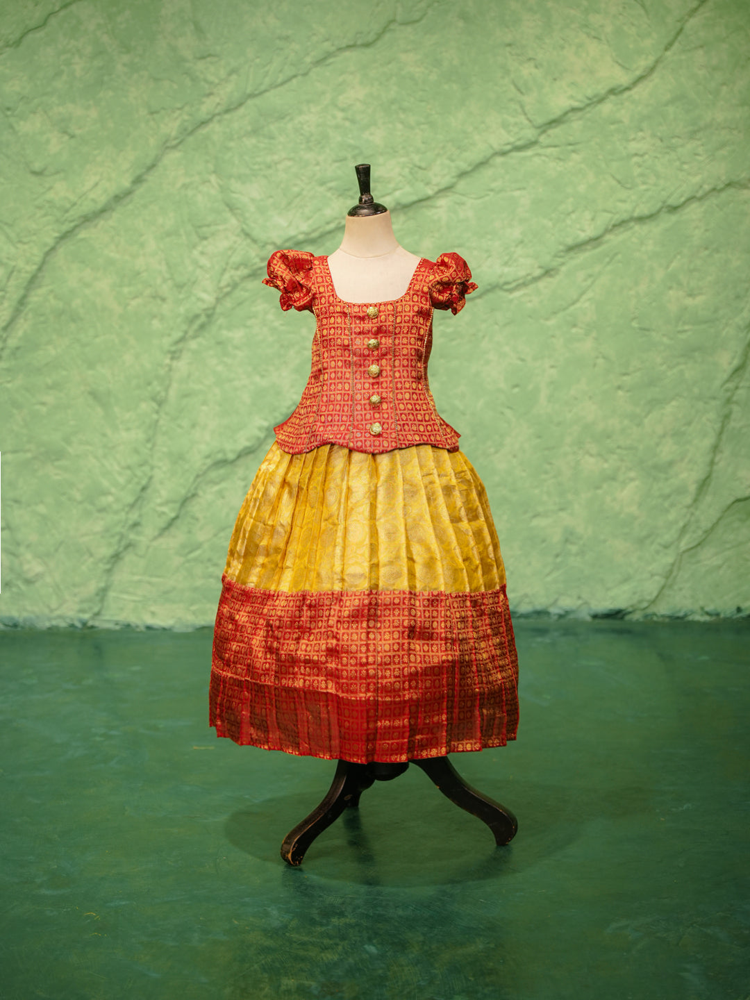 Red and yellow pattu pavadai in pure Kanchipuram silk with zari checks and puff sleeves — front view