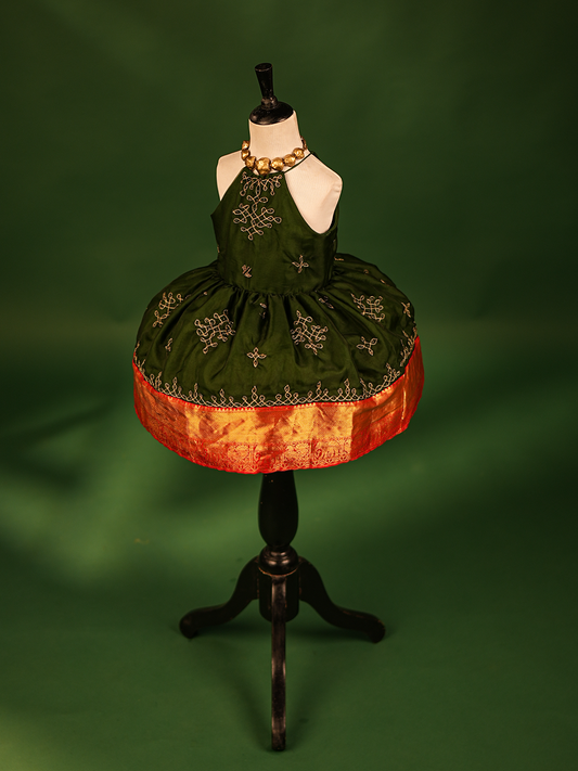 Half Scale green organza gown featuring intricate Kolam embroidery, a stylish halter neck, and a sleeveless design.
